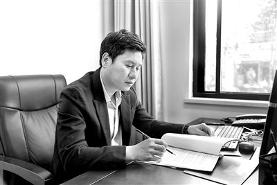 图为周岳锰在修改审查调查方案。 严尚 摄