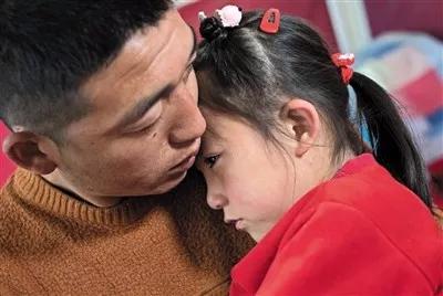 ▲大女儿在一旁落泪,曹永平把孩子揽在怀里,泣不成声。