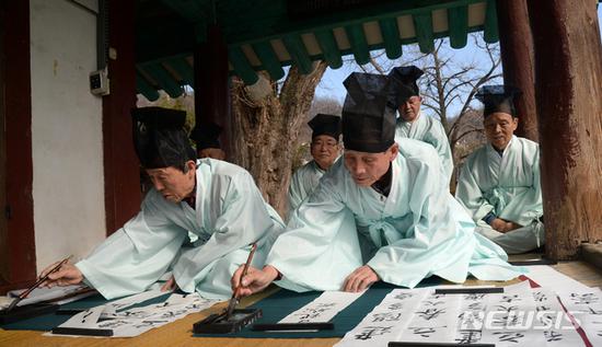 汉字对联:韩国人提前庆祝立春:贴汉字对联 白纸黑字亮了 30日,韩国全州的儒生们聚在一起写春联。(韩媒News1)