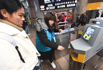 大学生志愿者在北京西站为旅客进行车票预检。