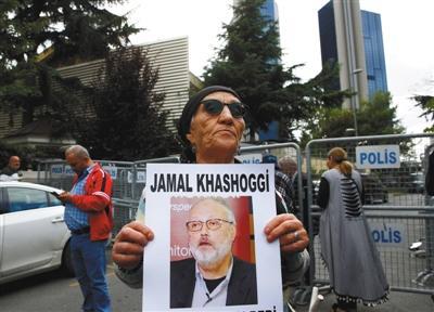当地时间10月9日，土耳其伊斯坦布尔，一名活动家拿着失踪沙特记者Jamal Khashoggi的照片在沙特驻伊斯坦布尔领事馆外抗议。 图/视觉中国