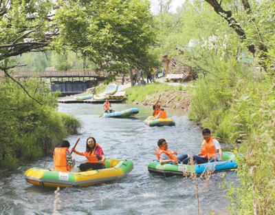 游客在露水河国家森林公园内体验漂流乐趣。 　　资料照片