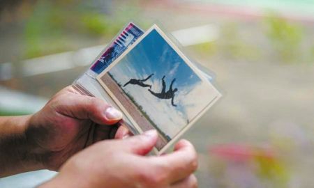 田纪恩手里拿着和杨勇(右)一起训练的照片。 图据新海南客户端