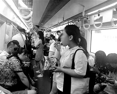 在地铁1号线，有乘客在吃膨化食品摄影/本报记者李强
