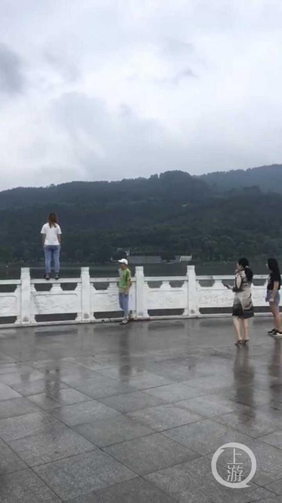 女孩站在神女湖栏杆上情绪低迷