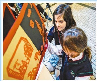 在意大利博洛尼亚国际儿童书展上，学生们观看中国孩子的原创图书。新华社记者 金 宇摄