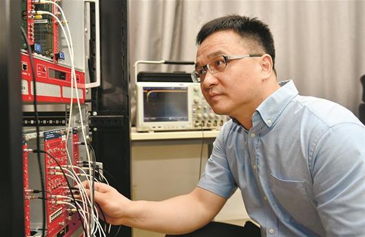 图为：谢庆国教授在进行光子探测实验