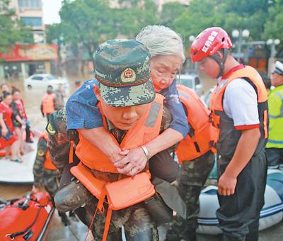 8月11日,浙江临海,武警救援人员将一位受困老人转移到安全地区。影像中国