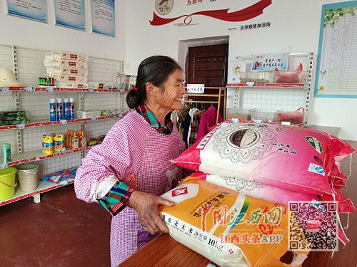 在义坪村“脱贫动力加油站”，贫困户凭积分兑换大米等物品。本报记者 钟珊珊摄