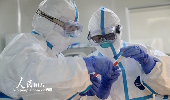 2020年1月31日，在浙江省湖州市德清县疾控中心新型冠状病毒感染肺炎病原体检测实验室，技术人员在开展新型冠状病毒感染的肺炎病例病原学检测。谢尚国/人民图片
