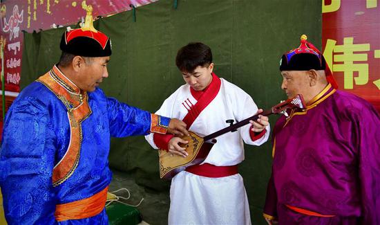 6月10日，内蒙古赤峰市巴林右旗的蒙古族说唱艺人（左一）在指导学生。新华社发（袁野 摄）