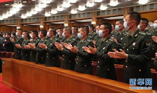 ·大会现场的解放军和武警部队官兵代表起立鼓掌。（图据新华网，翟子赫 摄）