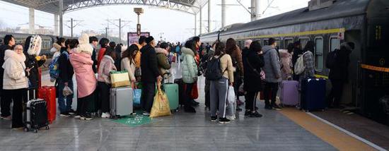 2019年2月16日，安徽省亳州火车站，返程旅客正在进站上车。视觉中国 图