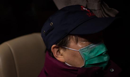 首批踏上返程的陕西国家紧急医学救援队队员崔雅清在乘车途中落泪（3月17日摄）。新华社记者 肖艺九 摄