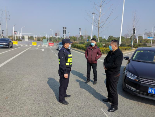 刘勋（中间）在江夏区高速路口巡查武汉出城道路封控情况