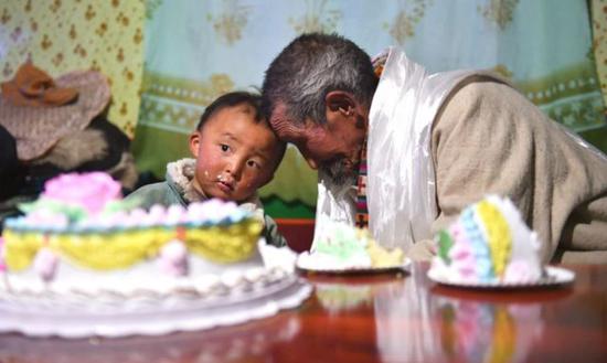 巴珠老人在生日聚会上和自己的曾孙碰额头，以示祝福。新华社记者 晋美多吉 摄
