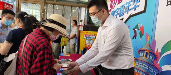 图为一名消费者正向北京一家银行工作人员咨询数字人民币的使用方法。新华社记者王晓洁 摄