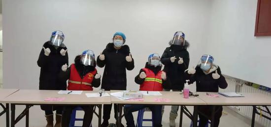 ▲王超（左三）和同事们一起投入到核酸检测采样登记工作中