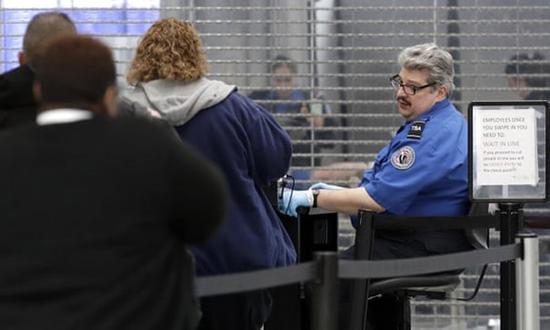 周五，在芝加哥奥黑尔国际机场，美国交通安全管理局办公室员工仍在安检站工作