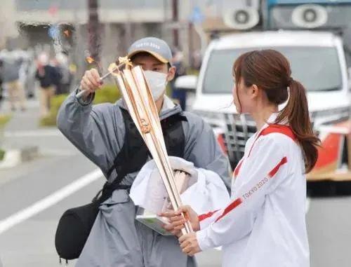 首日圣火熄灭，工作人员点火