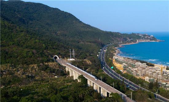 在海南环岛高铁东段陵水站附近，列车从海边驶过（2018年3月15日摄）。新华社记者 杨冠宇 摄