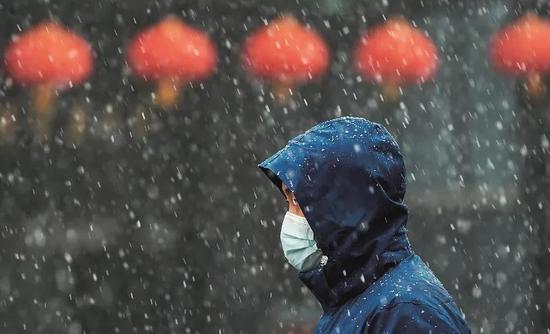 2月15日,一名市民在雪中前行。当日,受强冷空气南下影响,武汉气温骤降,午后迎来雨雪天气。图/新华