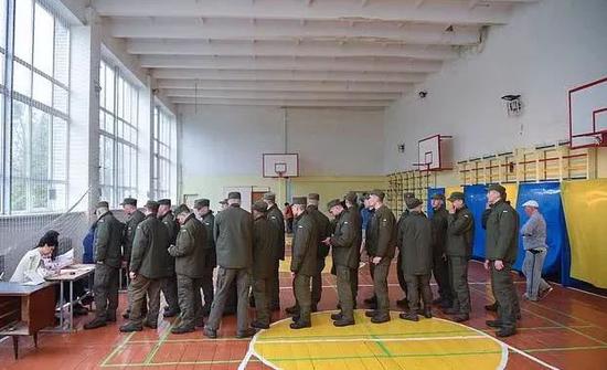 　在乌克兰西部城市利沃夫举行的第二轮总统选举中，乌克兰军人排队在投票站投票 