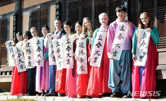 汉字对联:韩国人提前庆祝立春:贴汉字对联 白纸黑字亮了 外国留学生展示韩国书法家的春联作品。(纽西斯通讯社)