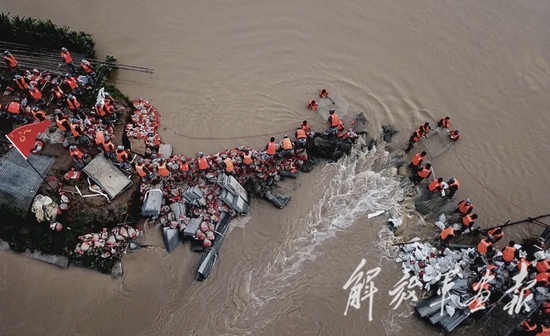 7月22日，在河南省开封市贾鲁河小岗凹河段，空降兵某旅官兵用石块、沙袋和钢管构筑子堤。余红春 摄