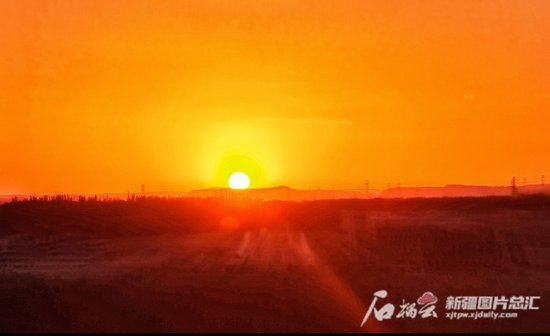 6月12日6时33分,乌鲁木齐天气晴朗,火红的朝阳从远处的地平线冉冉升起