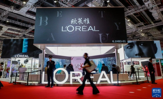 2020年11月7日，参观者走过第三届中国国际进口博览会消费品展区的欧莱雅展台。　新华社记者 张玉薇 摄