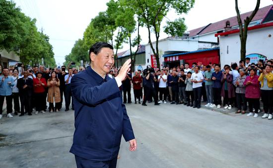 ↑这是13日下午,习近平在南阳市淅川县九重镇邹庄村考察时,向村民挥手致意。