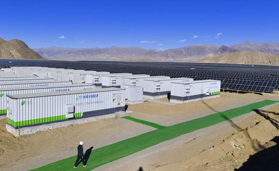 ↑2020年12月24日拍摄的日喀则市江当现代生态产业示范园内的50兆瓦光储电站储能系统和太阳能光伏组件。