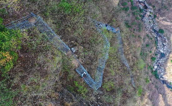 在四川省凉山彝族自治州昭觉县阿土列尔村的悬崖钢梯上,村民沿着钢梯下山(2020年5月13日摄)。新华社记者 王曦 摄