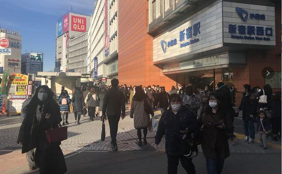 日本东京新宿地铁站口，戴口罩的人们。