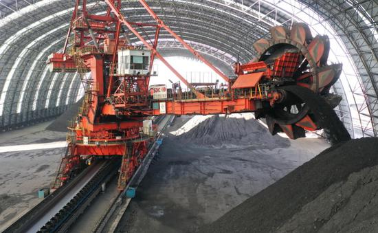  3月24日，工人在国投曹妃甸港煤仓操作机械设备卸煤。