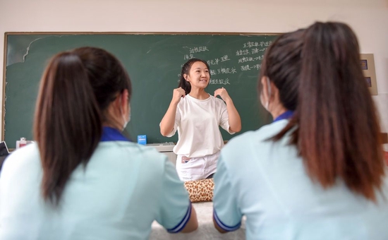 在内蒙古呼和浩特市特殊教育学校，王雅妮（中）给两位聋哑学生补课（2022年8月8日摄）。新华社记者 连振 摄