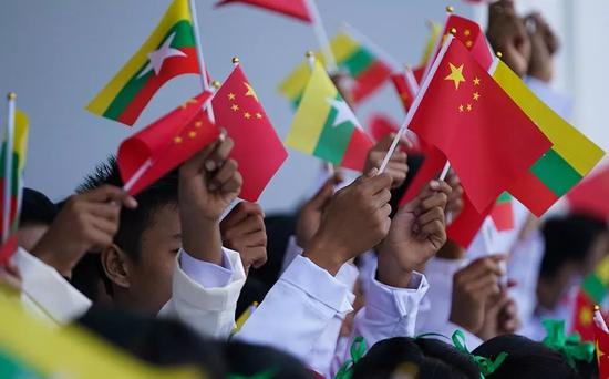 (缅甸青少年挥动中缅两国国旗,用缅文欢呼"中缅友谊万岁".