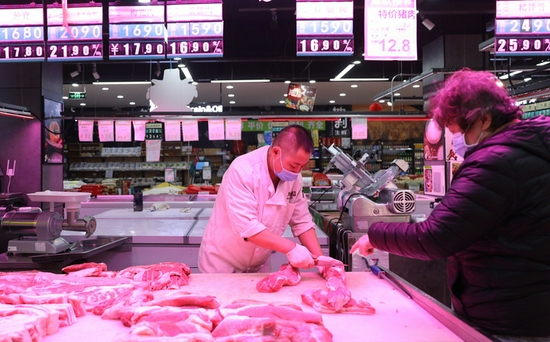  11月18日，辽宁大连一家生鲜超市的售货人员为顾客切分肉品。新华社记者 姚剑锋 摄