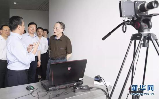  △王岐山在南京大学传感与成像技术实验室察看研究成果展示，了解科技攻关情况。
