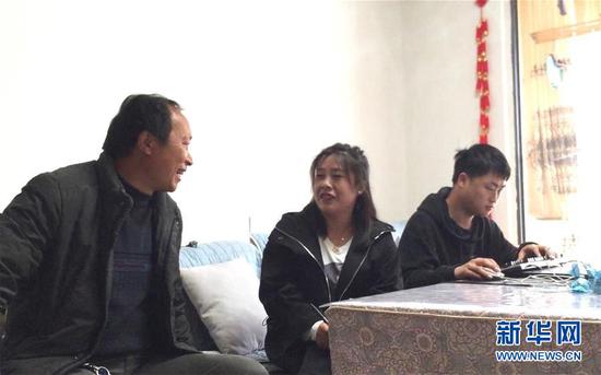 冯登友（左）和社区干部（中）在云南镇雄县鲁家院子易地扶贫搬迁安置点的家中交谈（4月21日摄）。新华社记者 林碧锋 摄