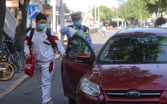交警帮忙打开车门，提醒家长送孩子即停即走。新京报记者 王贵彬 摄