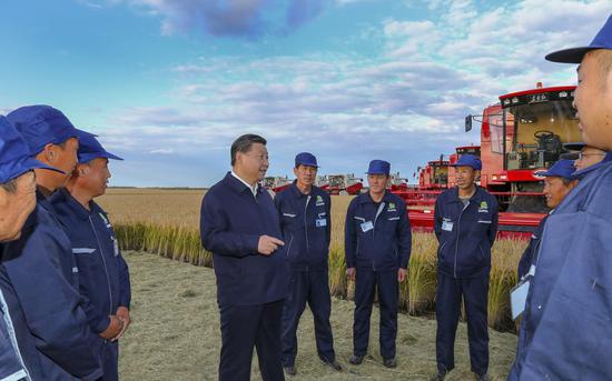 2018年9月25日，习近平在黑龙江农垦建三江管理局七星农场万亩大地号与农场工人们亲切交谈。