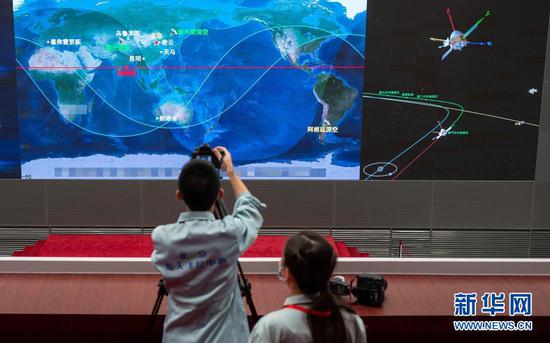 在北京航天飞行控制中心，航天科技人员在现场工作（2020年8月2日）。2020年8月2日7时整，我国首次火星探测任务“天问一号”探测器3000牛发动机开机工作20秒，顺利完成第一次轨道中途修正，继续飞向火星。新华社记者 才扬 摄