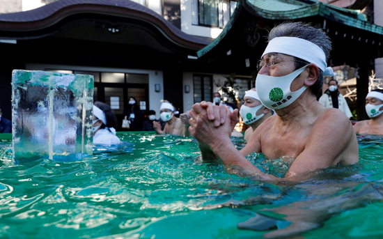 日本民众戴口罩泡冰水浴 祈祷新冠疫情结束(图)
