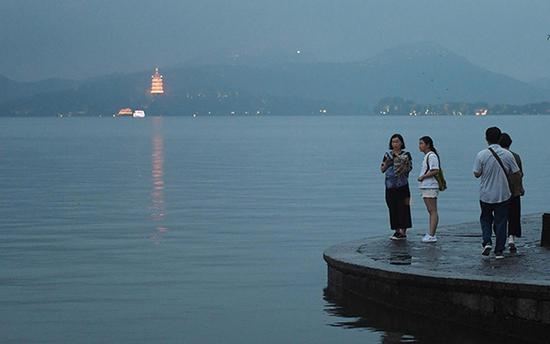 2019年7月13日，西湖水位上涨，游客游兴不减 视觉中国 图