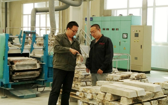 在内蒙古包头稀土研究院，科研人员胡文鑫（左）和同事分析合金断面（资料照片）。新华社发