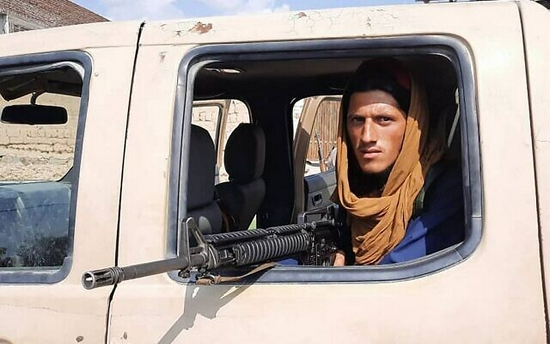  塔利班士兵坐在喀布尔街头的皮卡车里