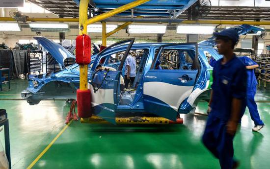 资料图片：深圳坪山新区比亚迪总部工厂，工人正装配一辆比亚迪e6纯电动新能源车。（新华社）
