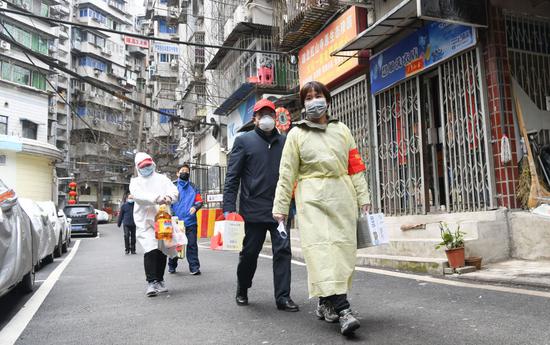 3月2日，武汉市江岸区球新社区干部郑捷（右一）和志愿者为社区里的低保户送货。新华社记者 程敏 摄